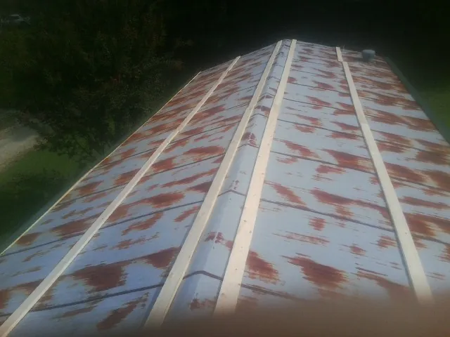 Rusted metal roof panels with new wood purlins before replacement — Storm Damage Roof Repair in Waddy by Roofing Brothers