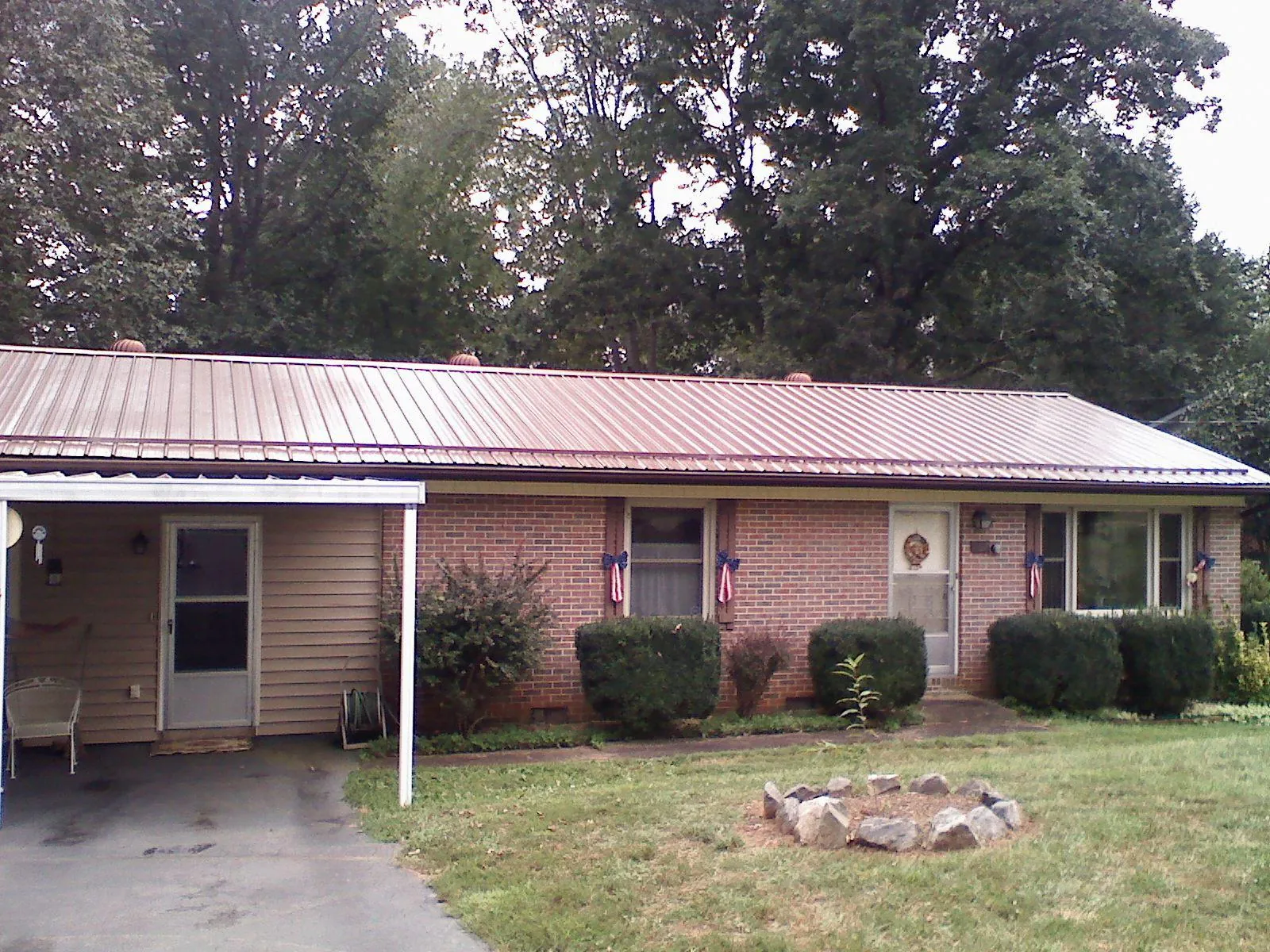 Bronze metal roof and carport on a brick ranch home — Roof Repair work by our crew in Waddy
